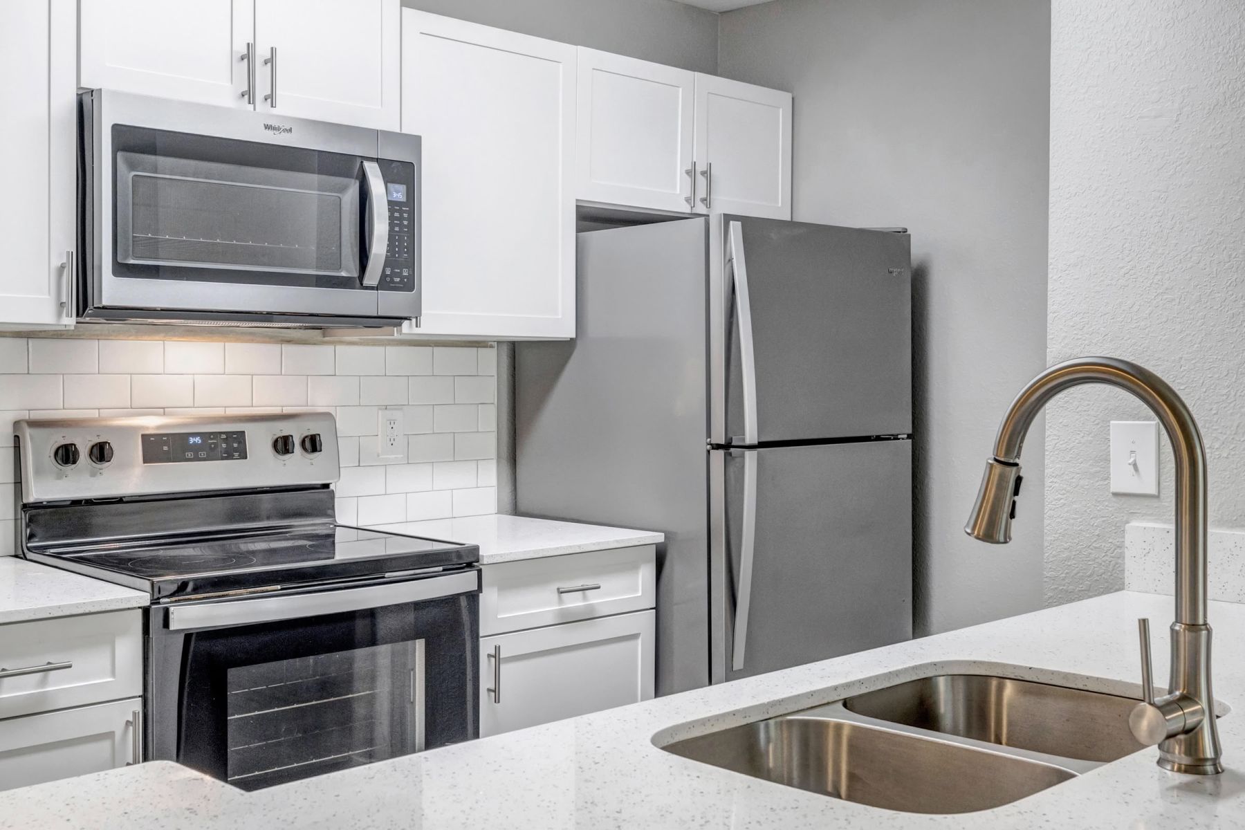 Luxury apartment kitchen with stainless steel appliances, granite countertops, and lots of storage space